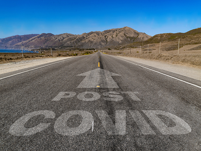 Long straight road with the text Post Covid showing on the surface below an arrow pointing in the same direction as the road.