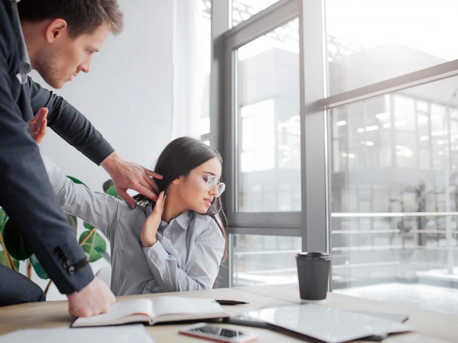 A man forcefully grabs a woman's shoulder; she appears distressed and resistant.