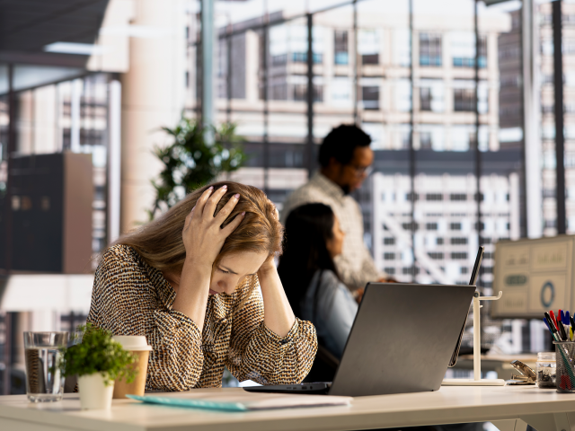 Stressed woman sitting at her office.